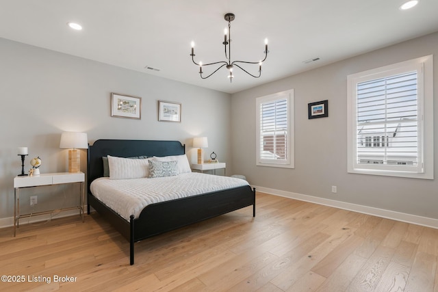 bedroom with a notable chandelier and light wood-type flooring