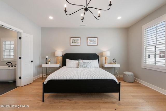 bedroom with light hardwood / wood-style flooring and an inviting chandelier