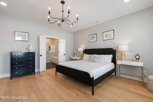 bedroom featuring ensuite bath, light hardwood / wood-style floors, and an inviting chandelier