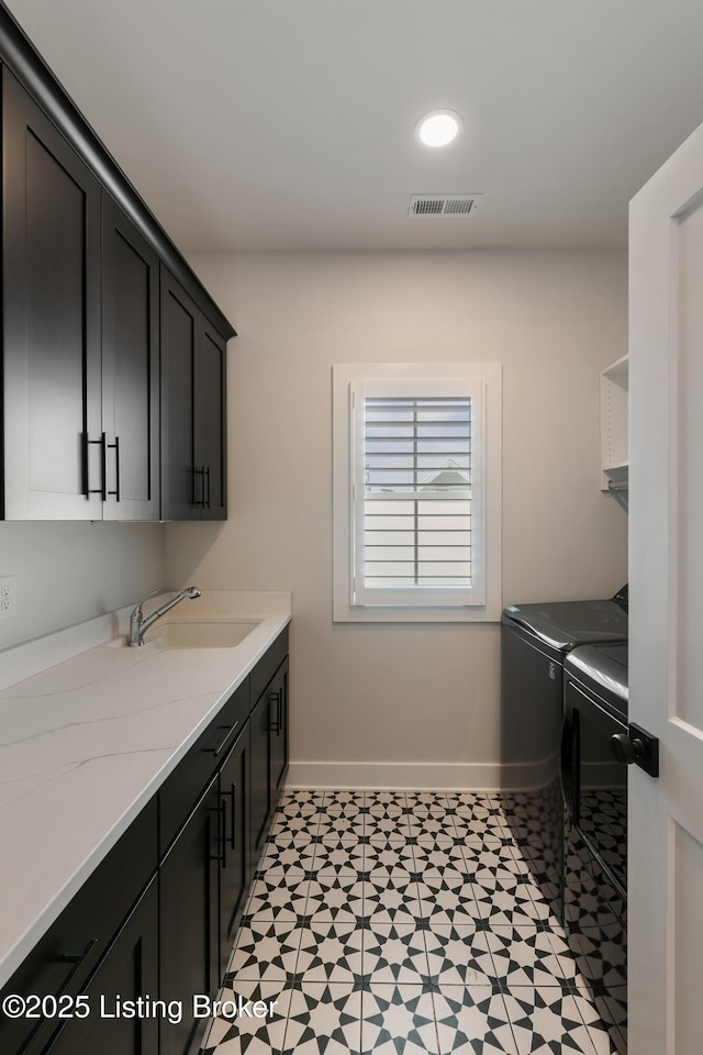 washroom with sink, cabinets, and independent washer and dryer