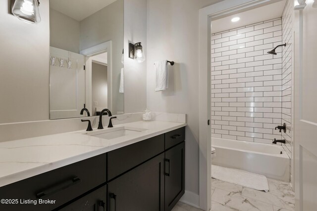 full bathroom featuring toilet, vanity, and tiled shower / bath