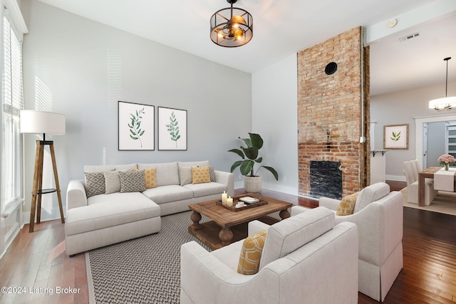 living room with hardwood / wood-style floors, a fireplace, and a chandelier