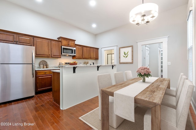 dining space featuring a notable chandelier and dark hardwood / wood-style flooring