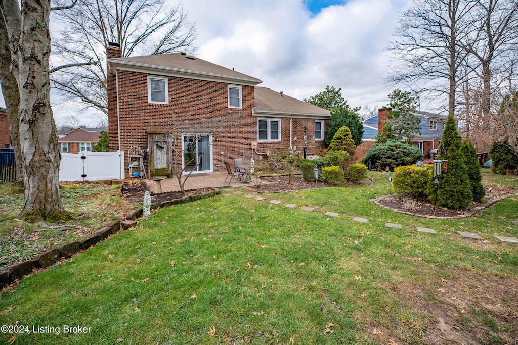 back of house featuring a patio area and a lawn