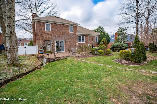 back of house featuring a patio area and a lawn