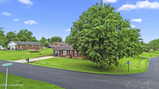 102 Eastland Dr, Bardstown, KY 40004 - view of front of property featuring concrete driveway, a front yard, brick siding, and view of wooded area
