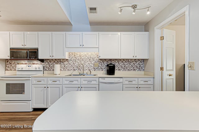 kitchen featuring white appliances, tasteful backsplash, white cabinets, and sink