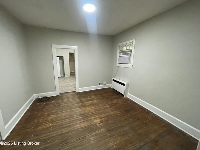 spare room featuring baseboard heating, cooling unit, and dark wood-type flooring