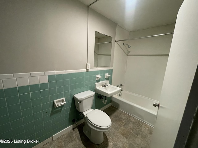 full bathroom featuring washtub / shower combination, toilet, tile walls, and sink