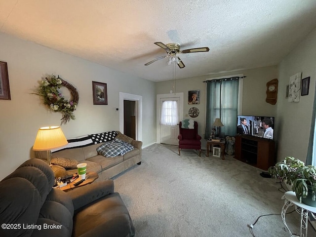 living room featuring carpet flooring, a textured ceiling, and ceiling fan