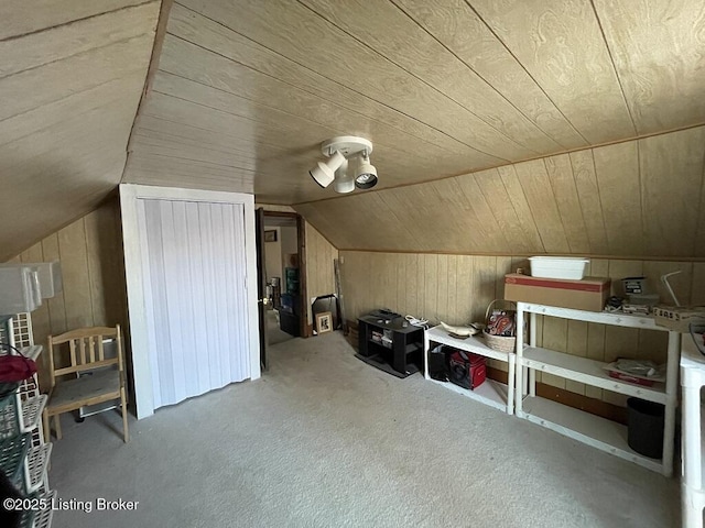 additional living space with carpet flooring, wood walls, wooden ceiling, and vaulted ceiling