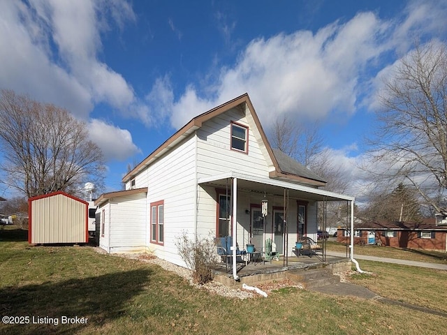 rear view of house with a lawn and a porch