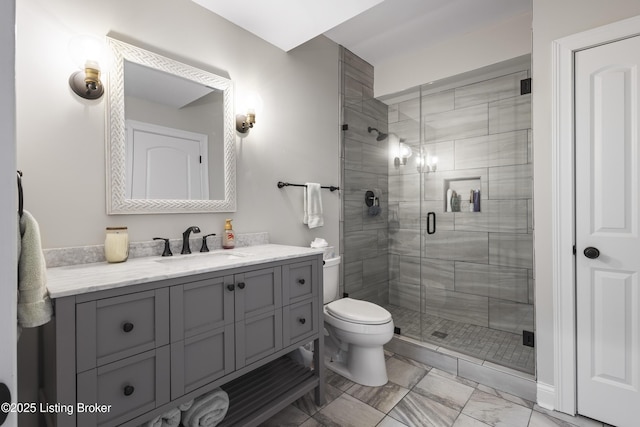 bathroom featuring toilet, a shower with shower door, and vanity