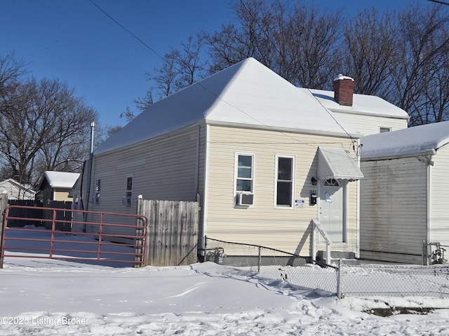 snow covered rear of property featuring cooling unit