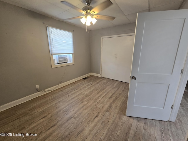 unfurnished bedroom with a closet, light hardwood / wood-style floors, ceiling fan, and cooling unit