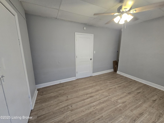 interior space featuring ceiling fan, light hardwood / wood-style flooring, and a drop ceiling