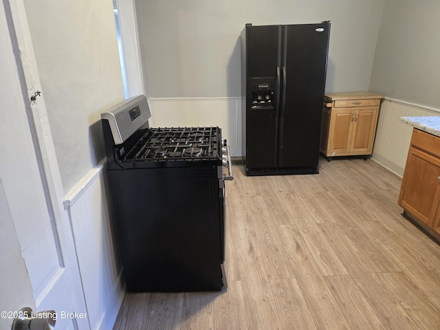 kitchen featuring light hardwood / wood-style flooring and black appliances