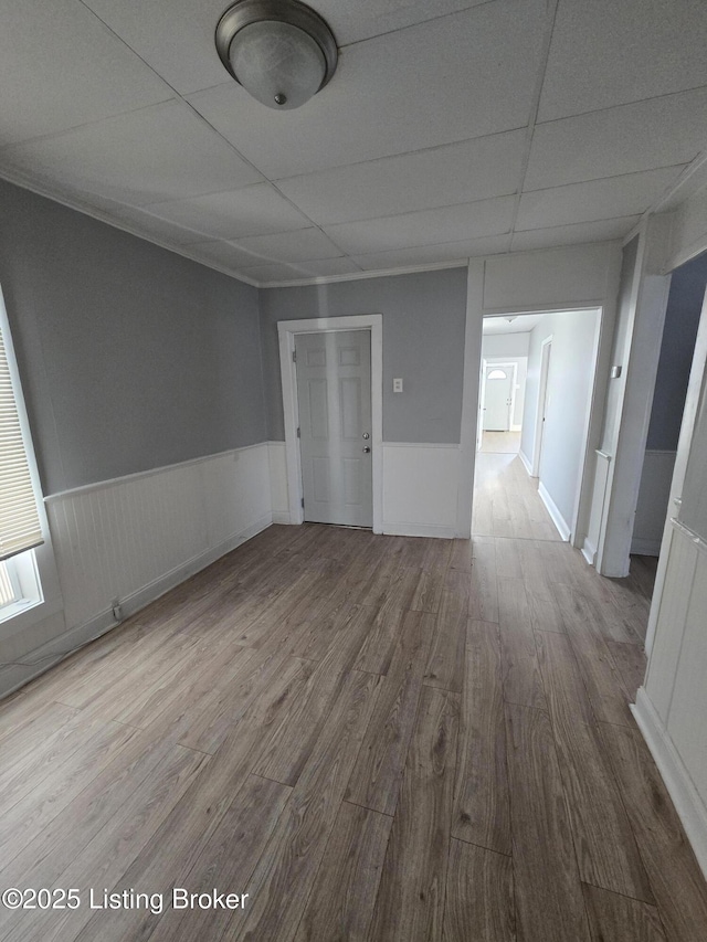 empty room with hardwood / wood-style floors and a drop ceiling