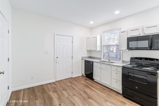 kitchen featuring black appliances, white cabinets, sink, light stone countertops, and light wood-type flooring