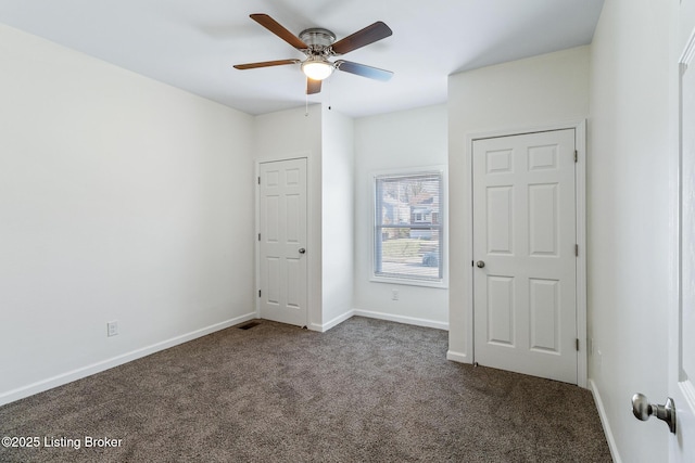 unfurnished bedroom featuring dark carpet and ceiling fan