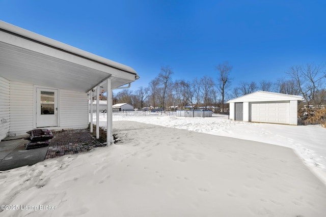 yard covered in snow featuring a pool, an outdoor structure, and a garage