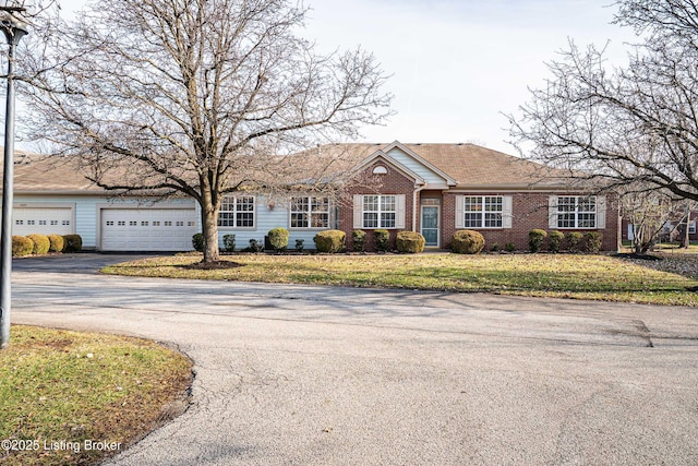 ranch-style house featuring driveway, a front yard, and brick siding