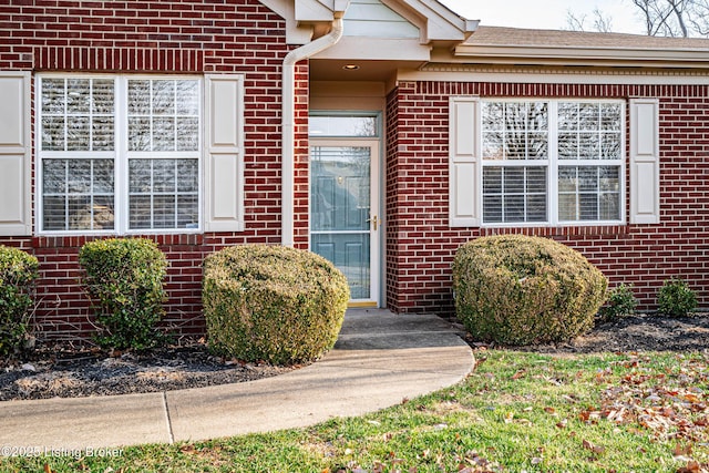 view of exterior entry with brick siding