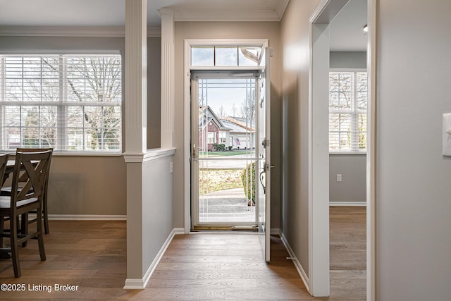 entryway with crown molding, baseboards, and wood finished floors