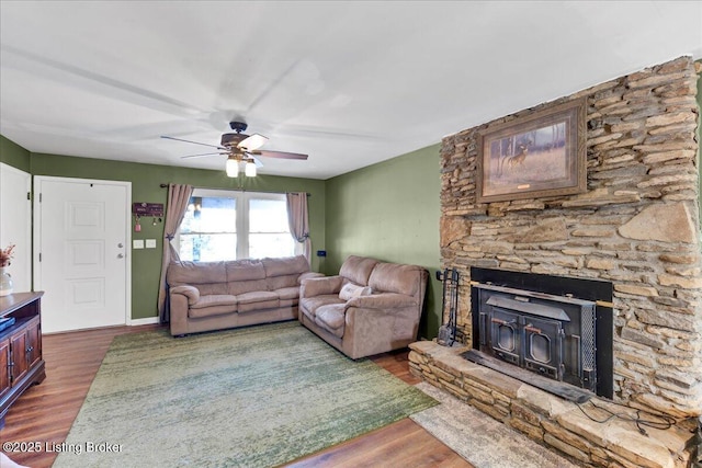 living room with ceiling fan, dark hardwood / wood-style flooring, and a fireplace