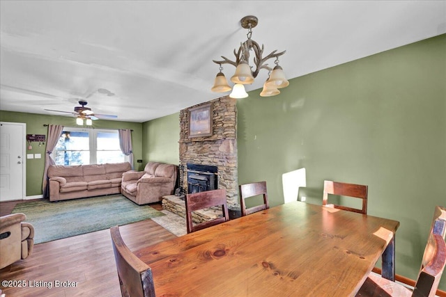 dining area featuring light wood-type flooring and ceiling fan with notable chandelier