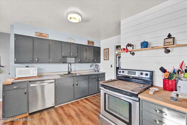 kitchen featuring sink, stainless steel appliances, light hardwood / wood-style flooring, and gray cabinets