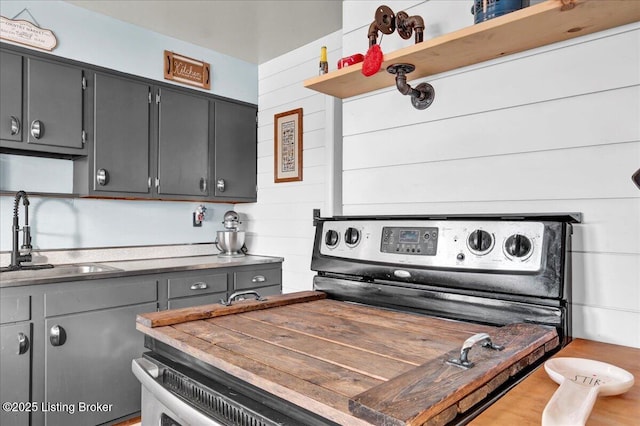 kitchen featuring sink, butcher block countertops, and stainless steel range with electric cooktop