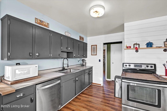 kitchen featuring stainless steel appliances, dark wood-type flooring, and sink