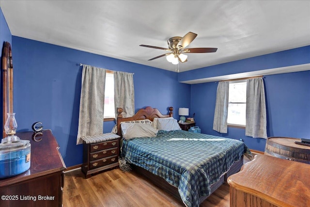 bedroom with multiple windows, ceiling fan, and hardwood / wood-style flooring