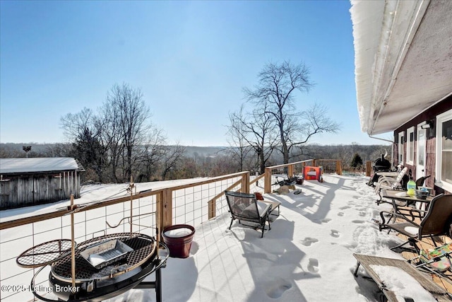 snow covered patio featuring an outdoor fire pit