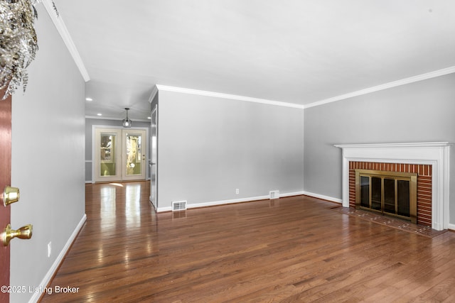 unfurnished living room with a brick fireplace, crown molding, and dark wood-type flooring