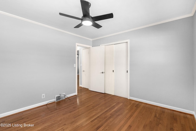 unfurnished bedroom with hardwood / wood-style flooring, ceiling fan, a closet, and ornamental molding