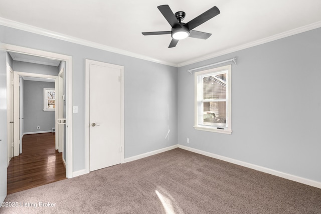 unfurnished room with dark carpet, ceiling fan, and crown molding