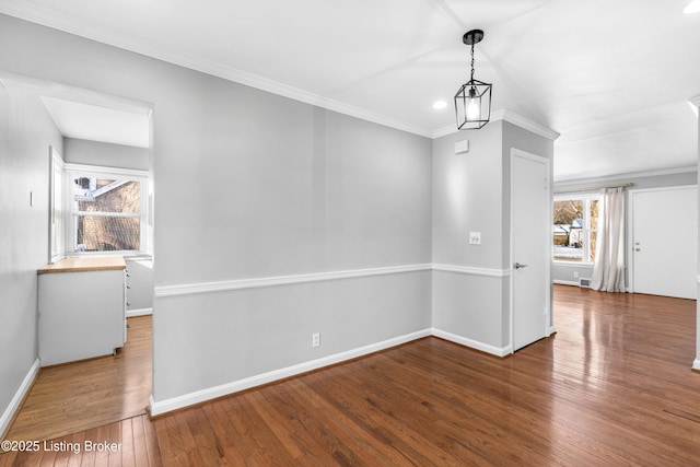 interior space with an inviting chandelier, hardwood / wood-style floors, and crown molding