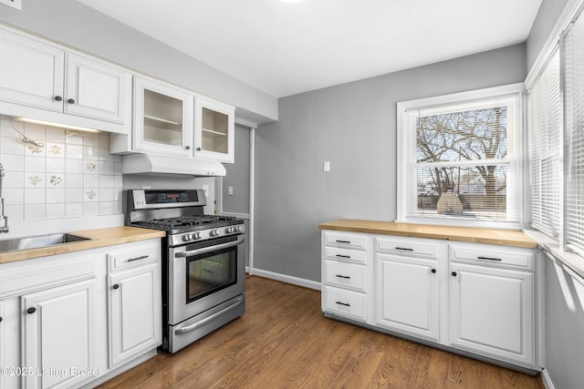 kitchen featuring white cabinetry, stainless steel range with gas cooktop, decorative backsplash, and butcher block counters