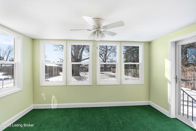 unfurnished sunroom with ceiling fan