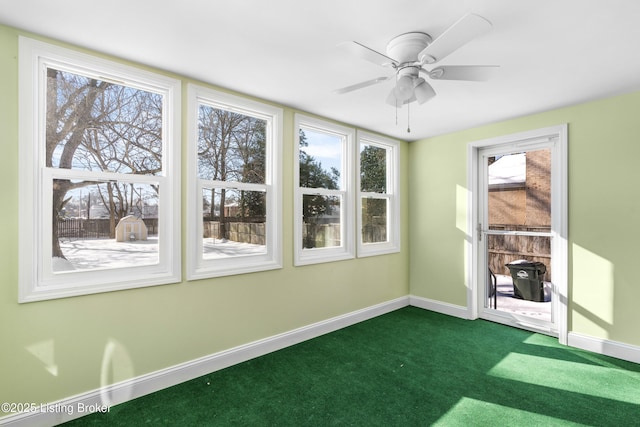 unfurnished sunroom with ceiling fan