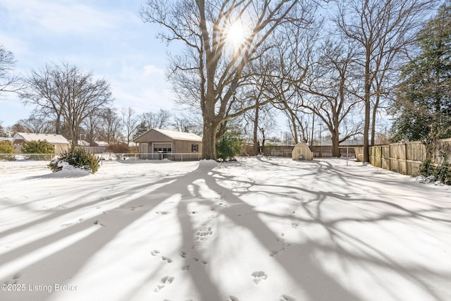 yard covered in snow with a shed