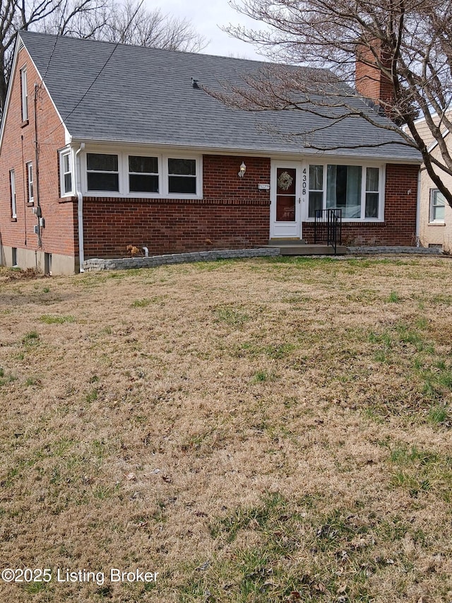 ranch-style house with roof with shingles, brick siding, a chimney, and a front lawn