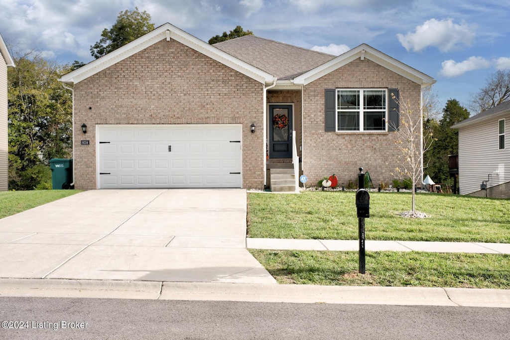 view of front of property featuring a front yard and a garage