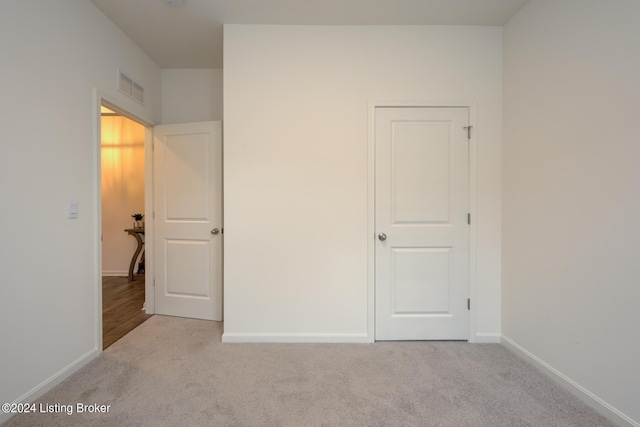 unfurnished bedroom featuring light carpet