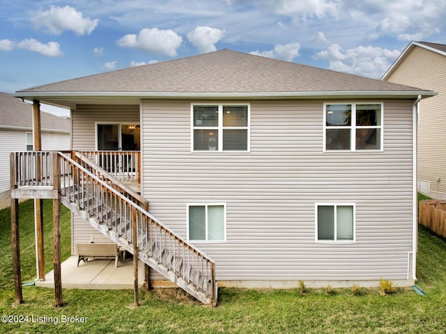 rear view of property featuring a lawn and a patio