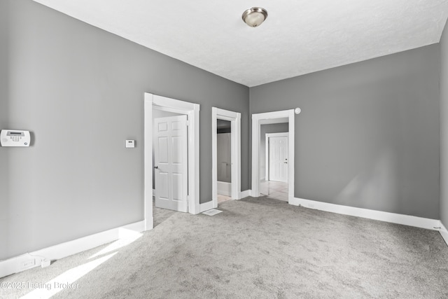 unfurnished bedroom featuring light carpet and a textured ceiling