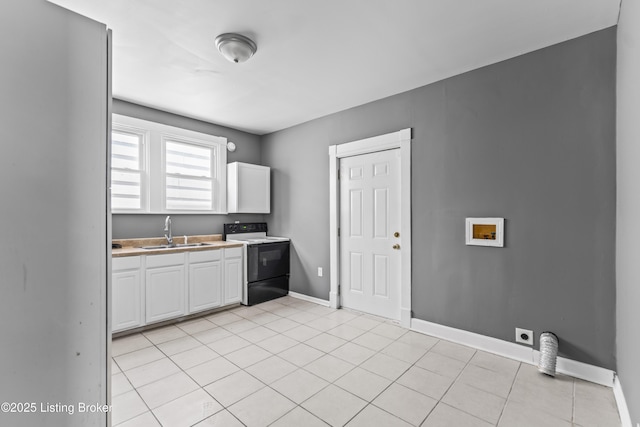 kitchen featuring white cabinetry, sink, electric range, and light tile patterned flooring