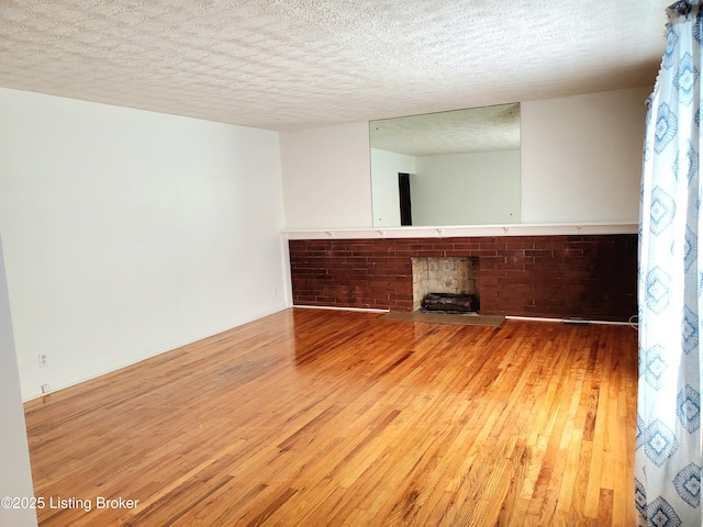 spare room with a textured ceiling and wood-type flooring